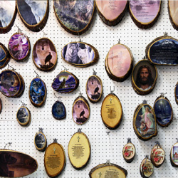 wooden plaques with images hung haphazardly on a wall